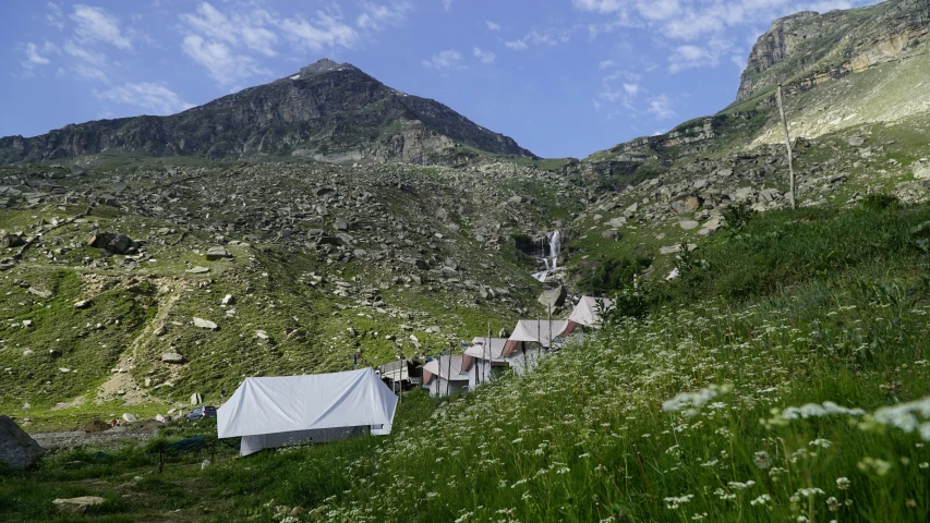 a mountain landscape with a tent and house next to it