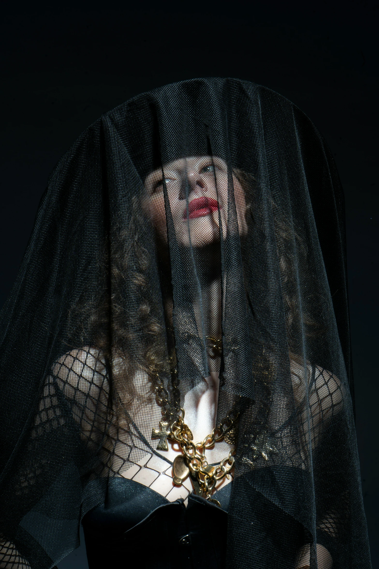 the woman is wearing an elaborate veil and necklace