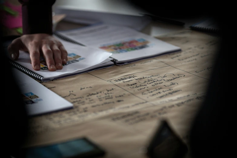 the hand of a woman touching a piece of writing on a binder