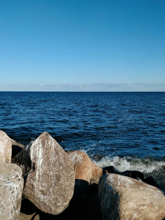 the water is very blue with some big rocks