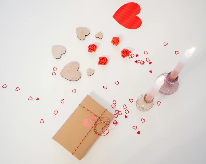 a brown package of chocolate with a candle on it and some red paper hearts