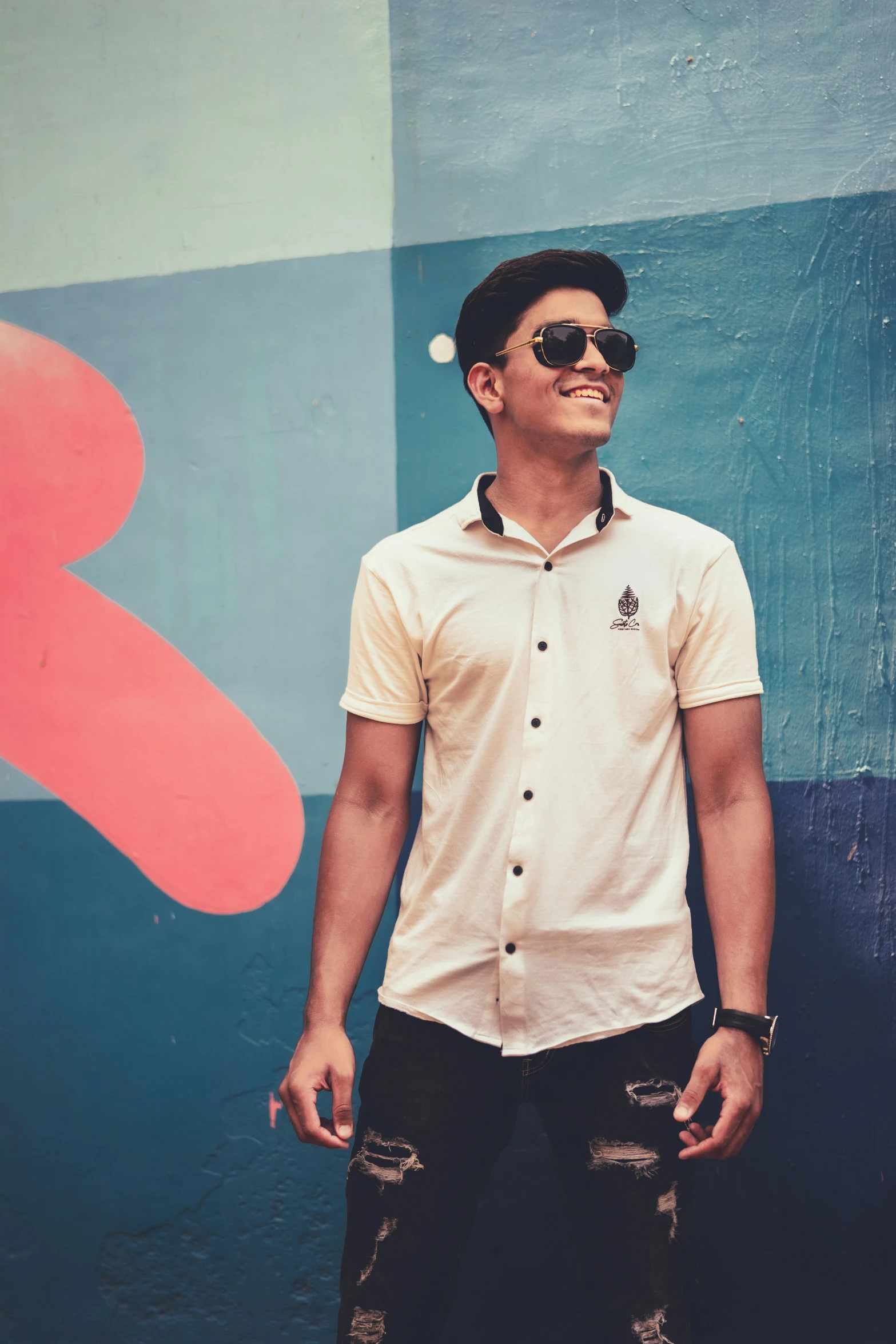 a man in shades and his skateboard next to him