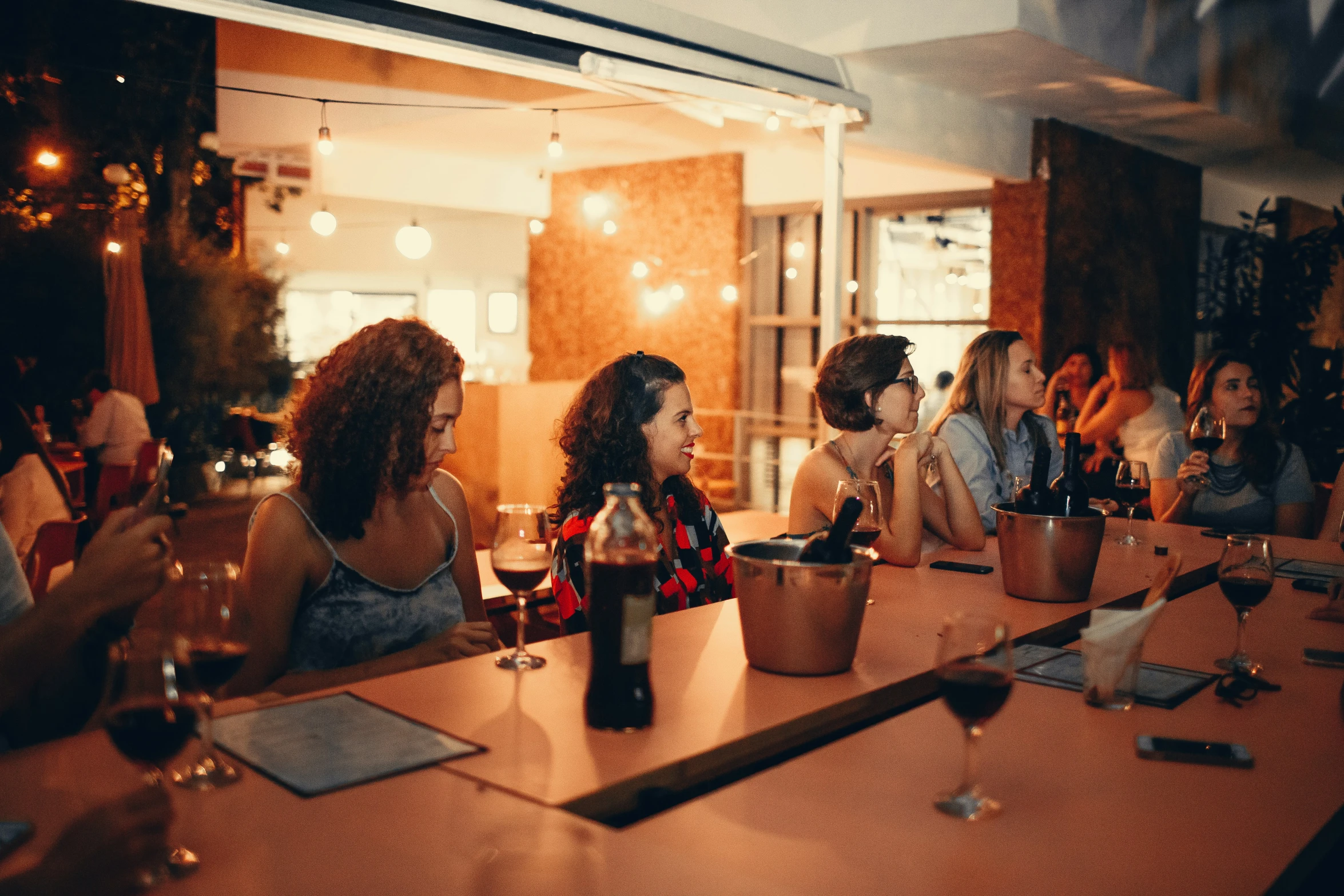 four women sitting at a table and two people standing