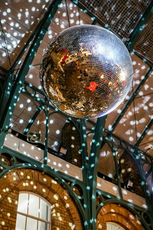 a large mirror ball is suspended above a building