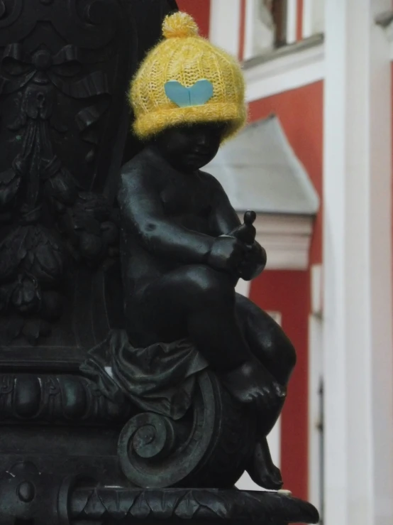 a black figure of a child with a yellow hat on and on