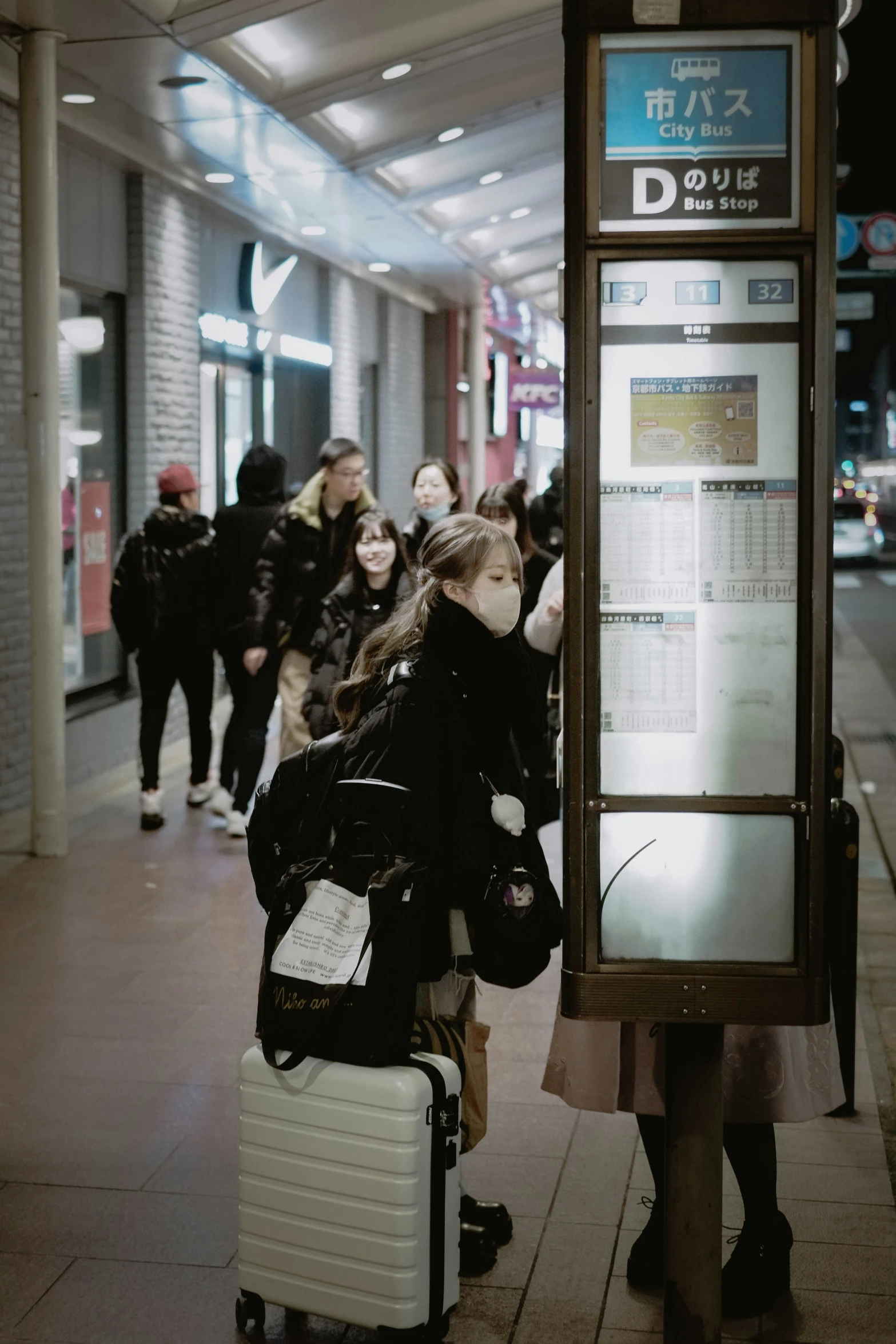 a group of people walking down a sidewalk with luggage