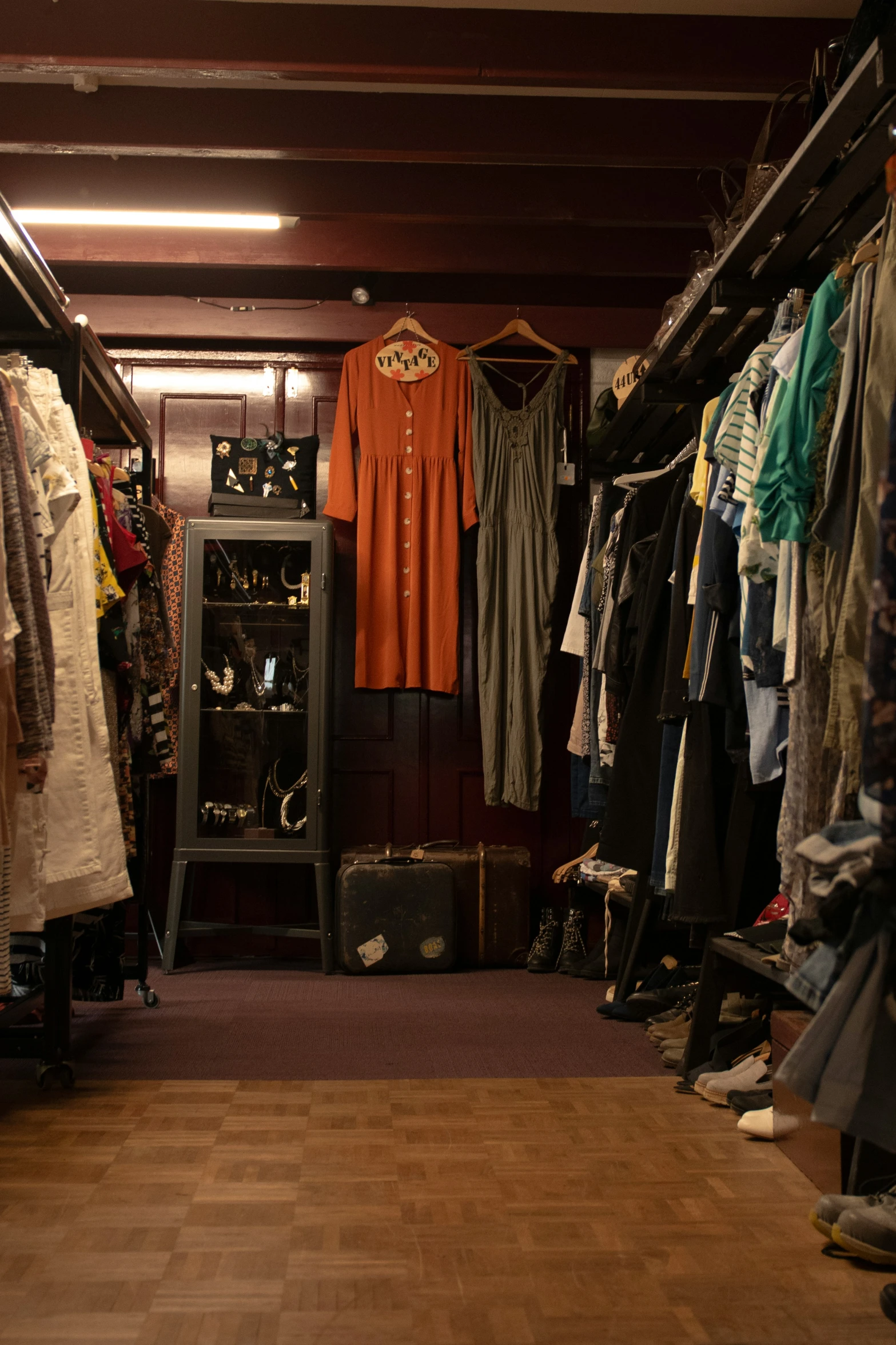 an open closet with clothes and clothing racks