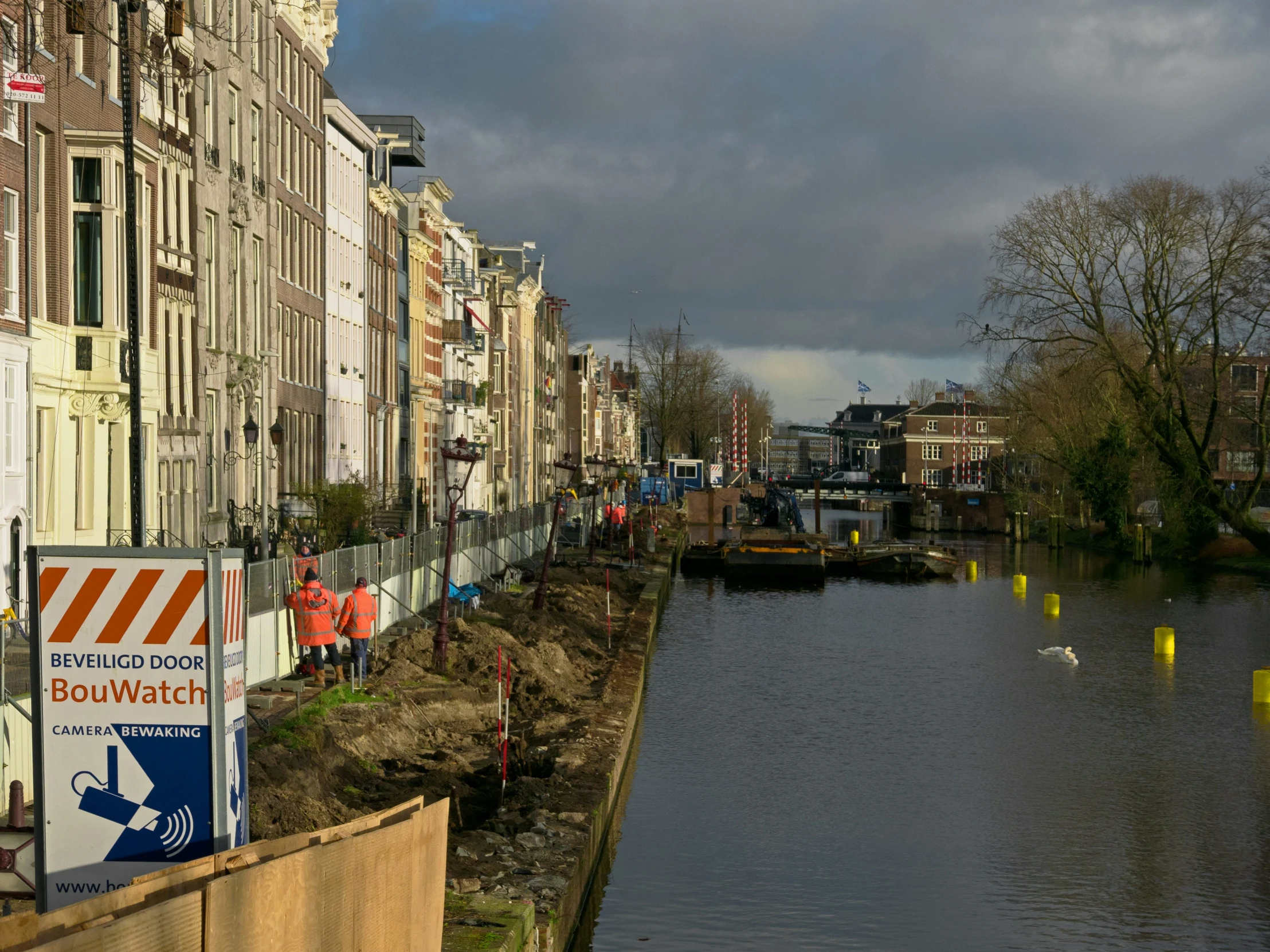 houses along the edge of a canal under a dark sky