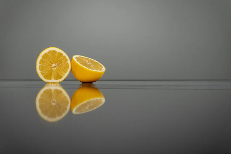 two halves of an orange on top of a black table