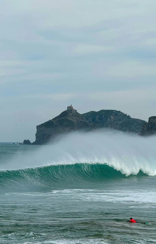 a man in a canoe riding a large wave