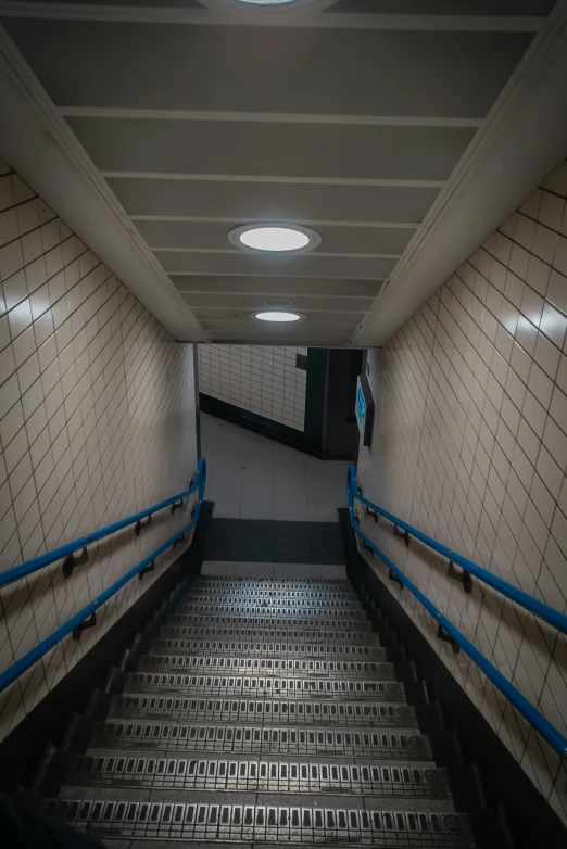 a long stair with light above it and tile walls