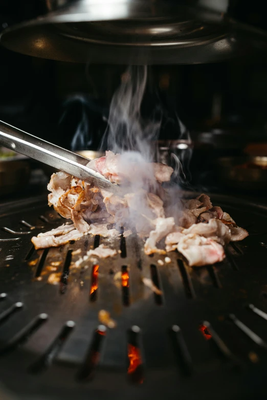 a close up view of meat cooking in the grill