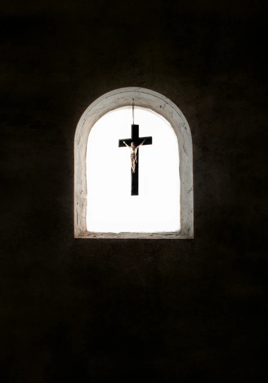 a cross that is hanging in a wall