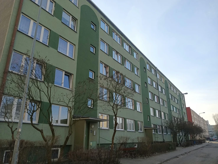 an empty street outside a tall green building