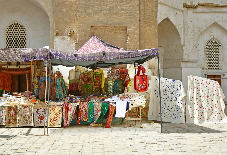 some colorful fabrics are on sale at an outdoor market