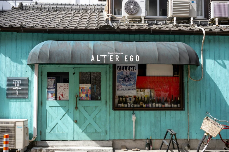 the front door of a teal shop and bicycle parked outside