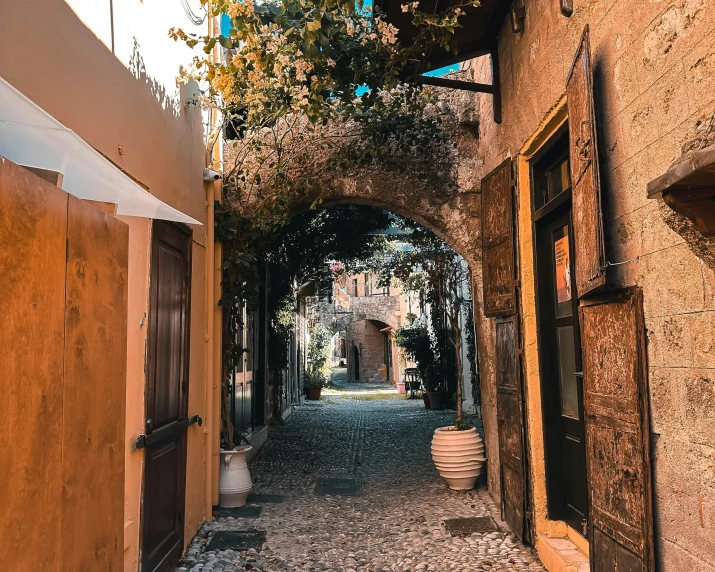 an empty alley between brick buildings and large doors