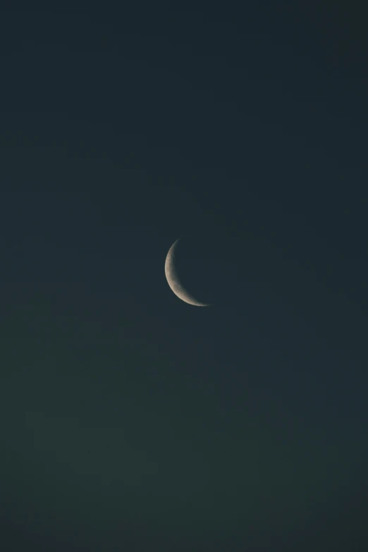 a half moon is pictured against the dark blue sky