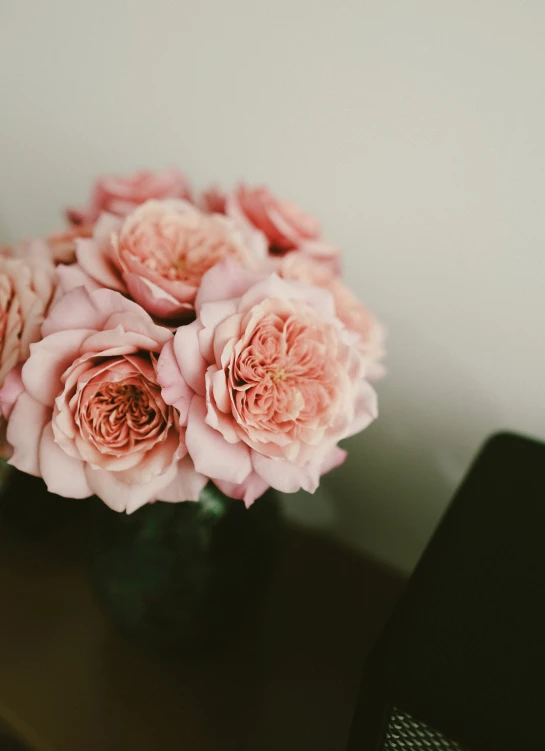 some pink flowers sit in the middle of a vase