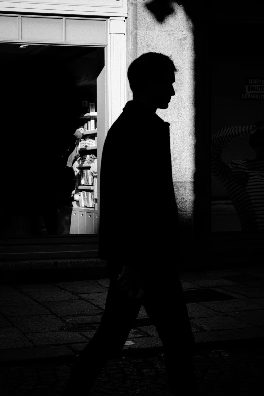 a man walking down the sidewalk while looking out