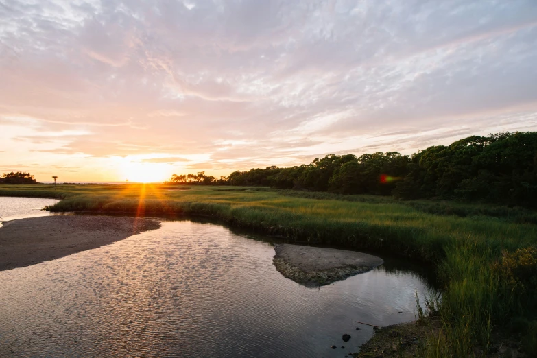 the sun is setting over a calm river