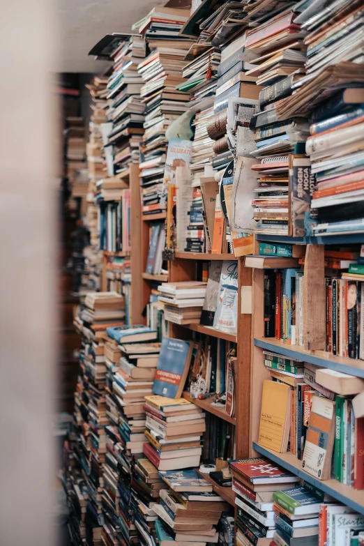 a pile of books stacked on each other on the side of a wall