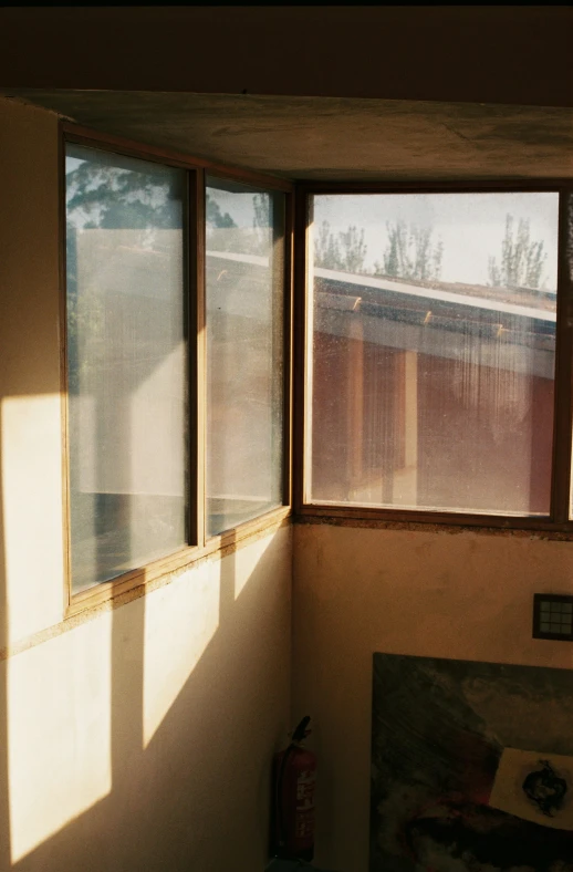 a room with multiple windows that has the sunlight in them