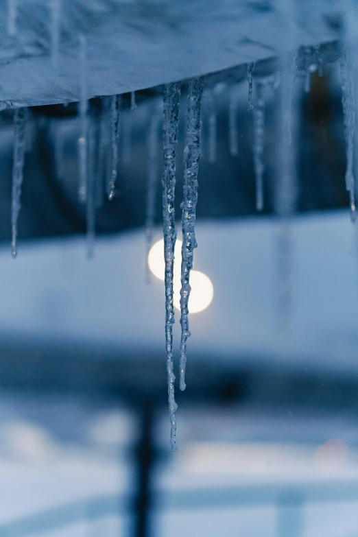 a snow covered lamppost and some icicles hanging from it