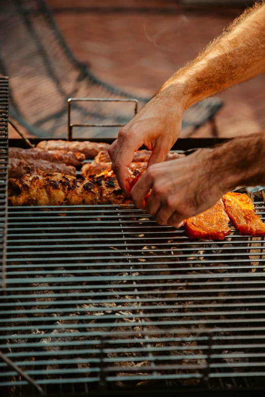 a person with their arm over a grill