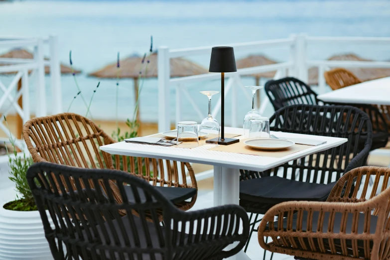 a couple of brown chairs are outside by a table