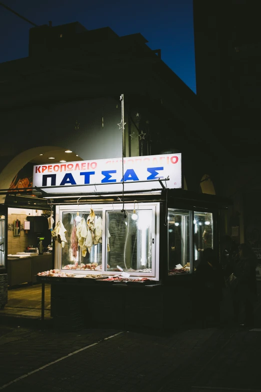 a storefront at night that displays clothing and clothing items