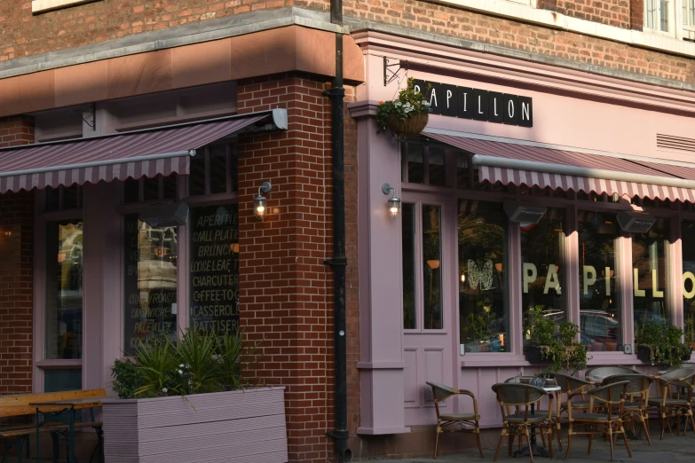 a storefront is shown with tables and chairs outside