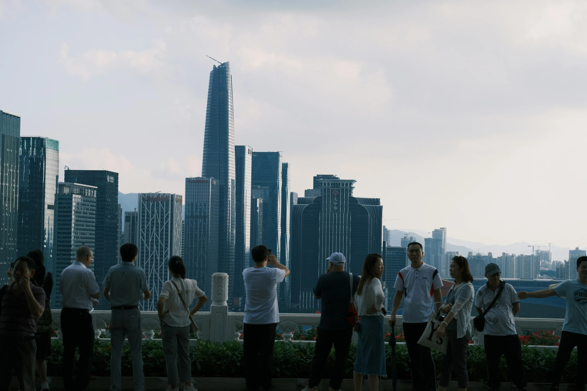 people looking at the skyscrs from top of a building