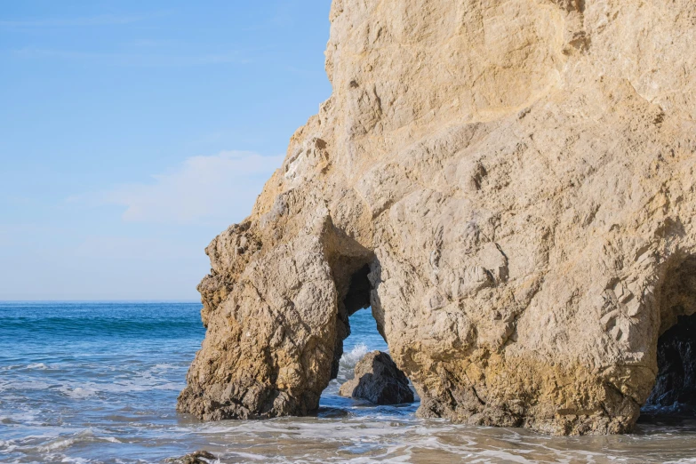 a large rock formation sitting in the middle of the ocean