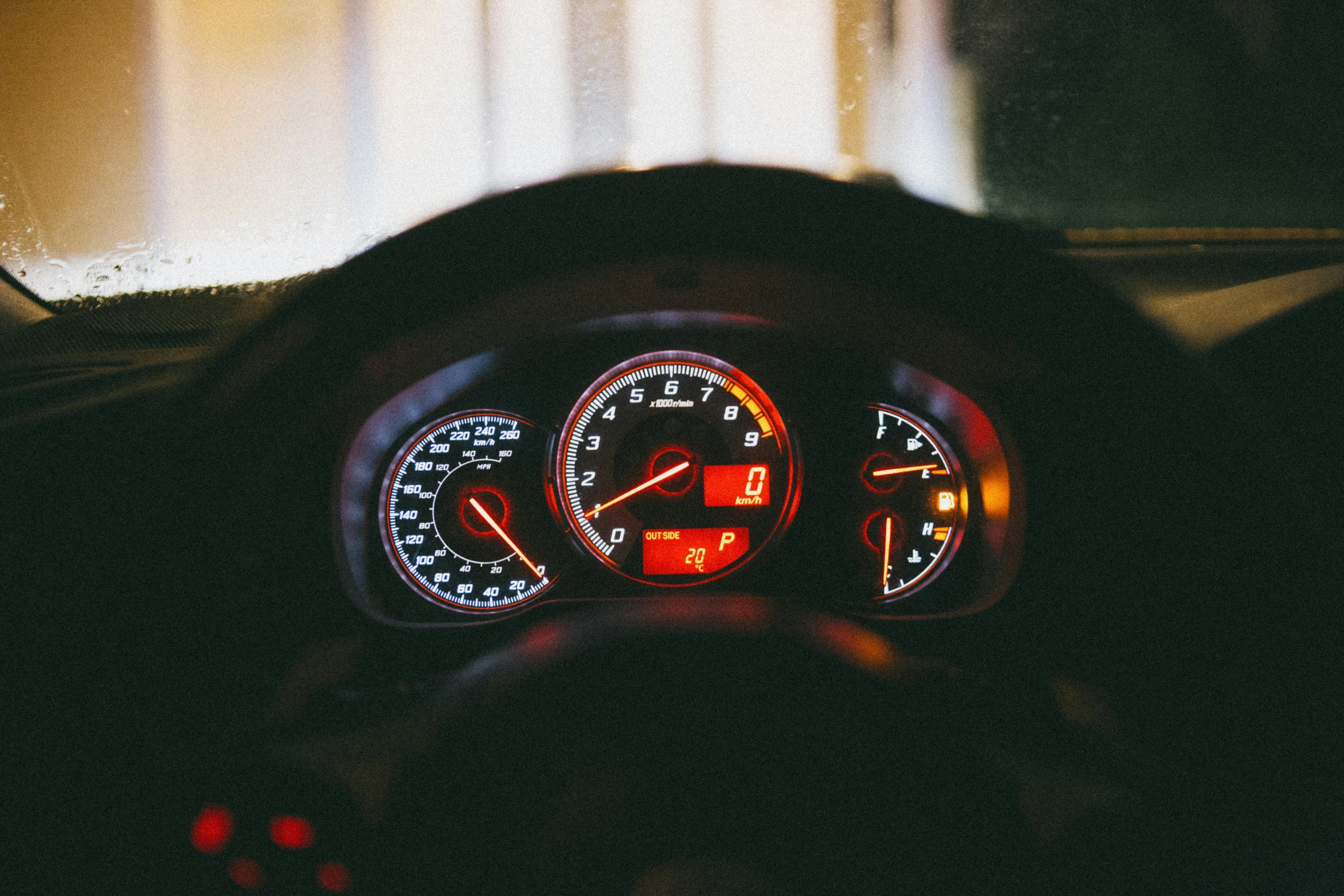 the dashboard of a car at night with its light on