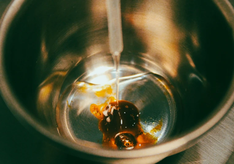 an object in a metal bowl with liquid