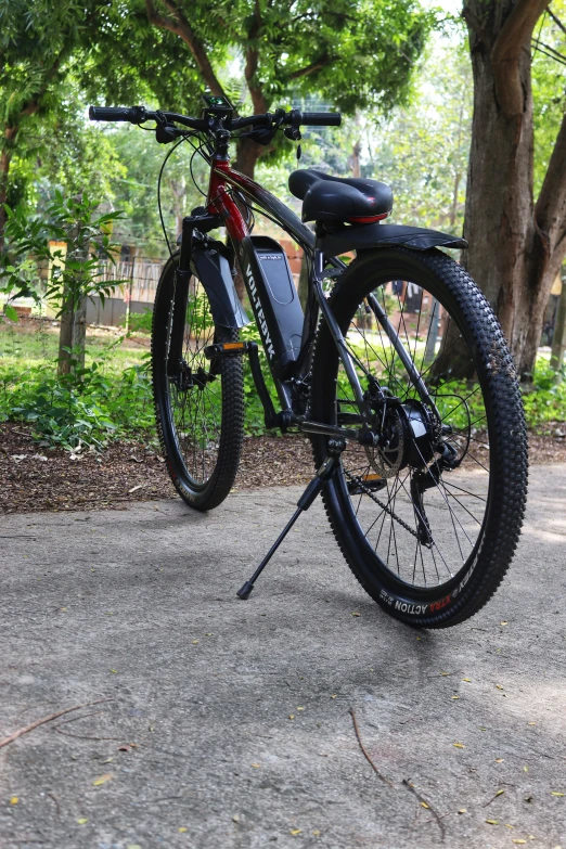 a black bicycle is parked on a cement slab