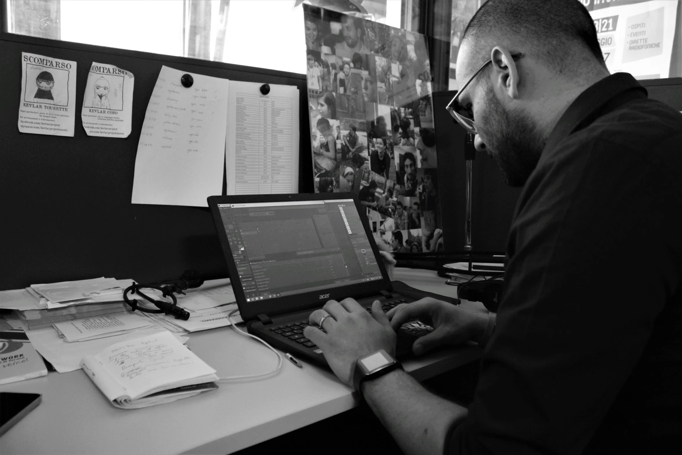 a man sitting at a desk typing on a laptop