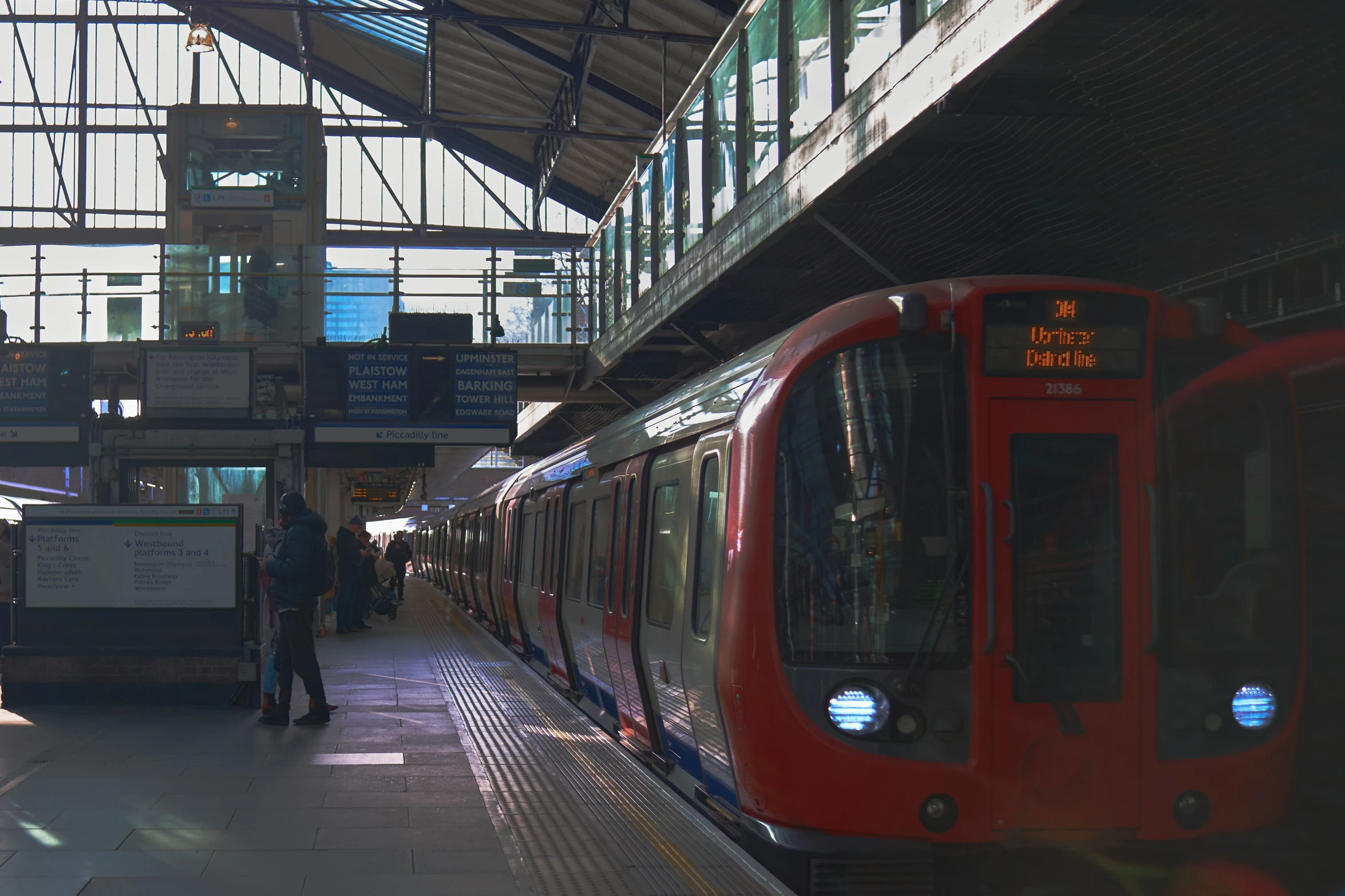 a red train that is next to a station