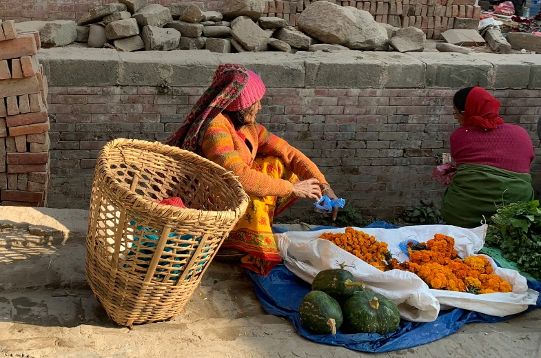 two women standing in front of baskets filled with flowers