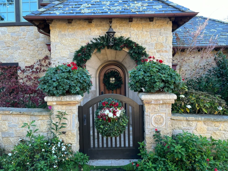 an ornate wooden gate in front of an old house with plants