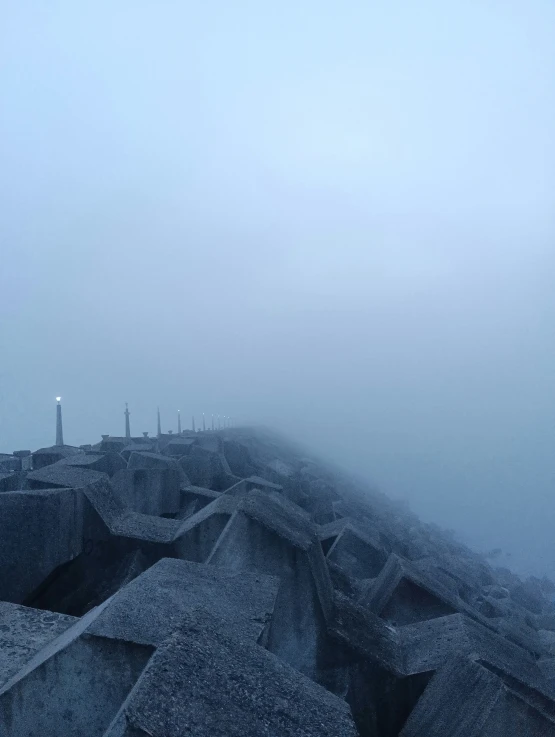 the fog covers the rocky outcropping of an industrial port