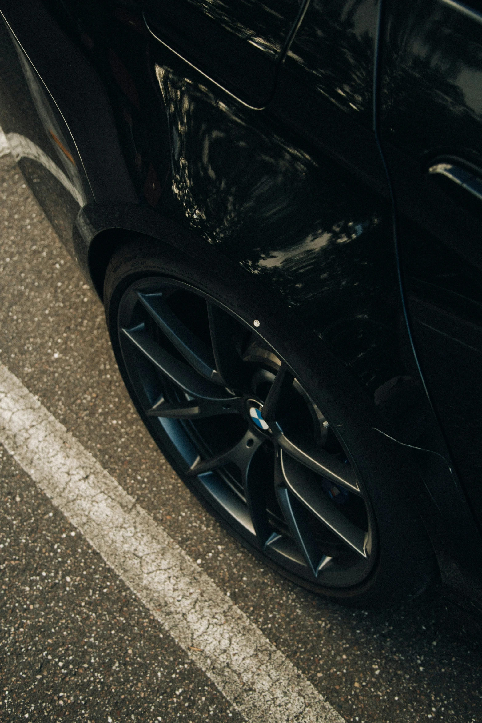 black car parked on the side of the street in front of someone