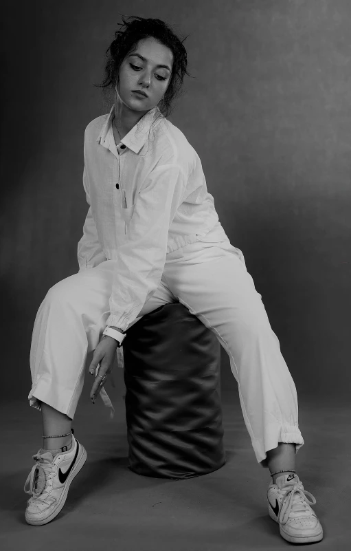 a woman with curly hair sitting on top of a stool