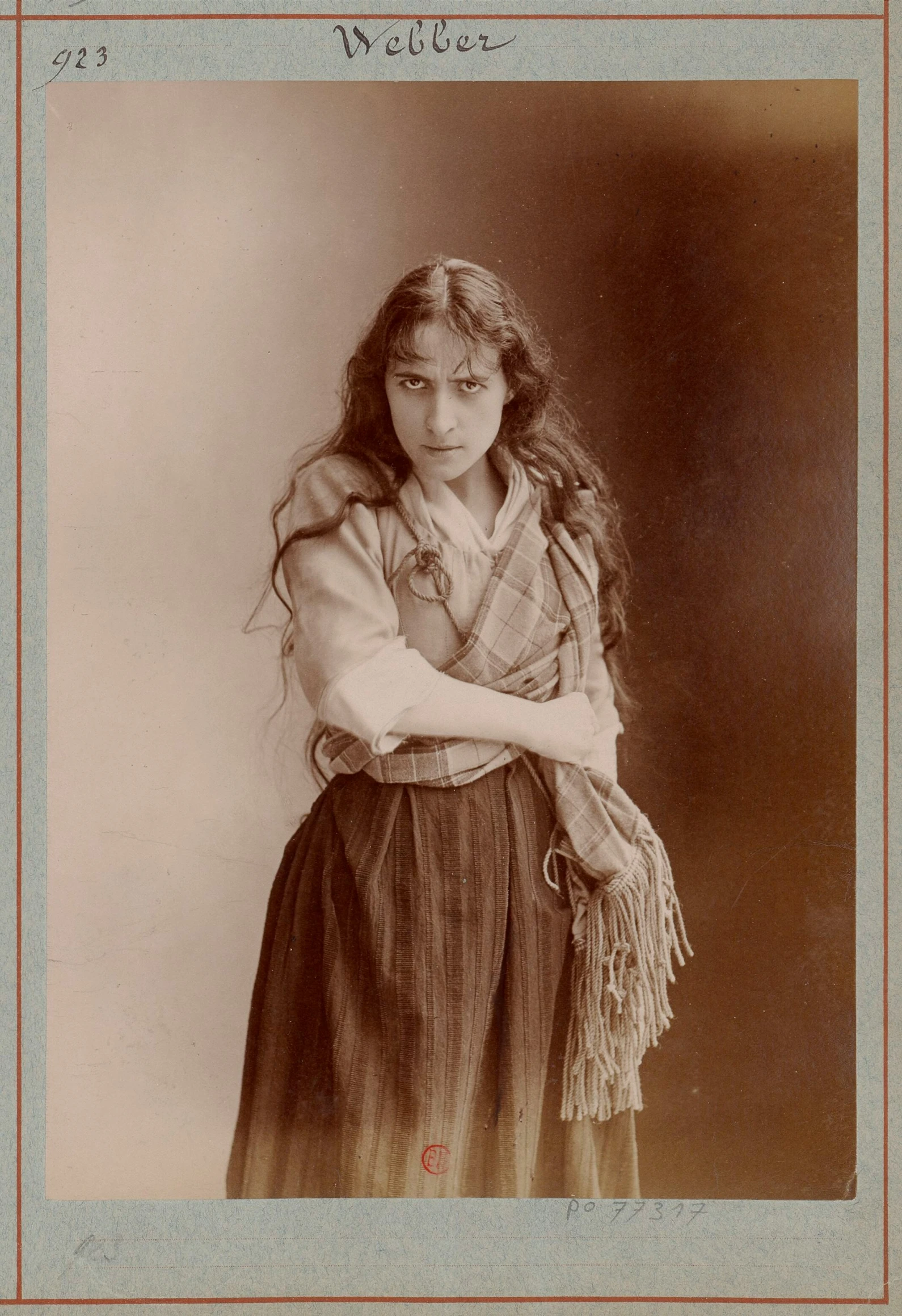 a woman poses for a portrait while holding her arms folded