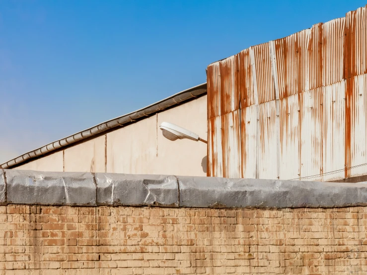 the side of a building with rusty metal on it