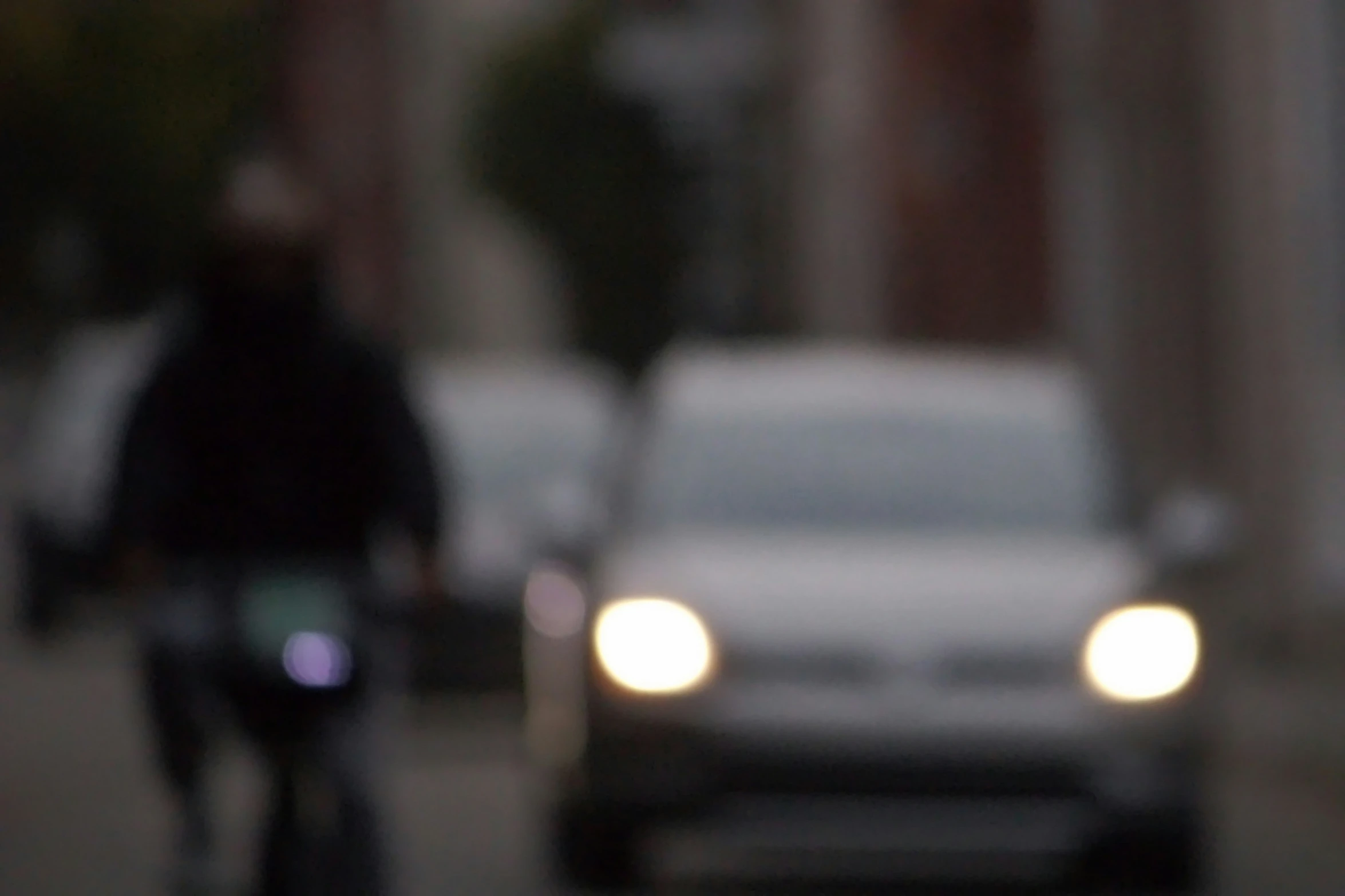 a blurred car and person on their bicycle in the street