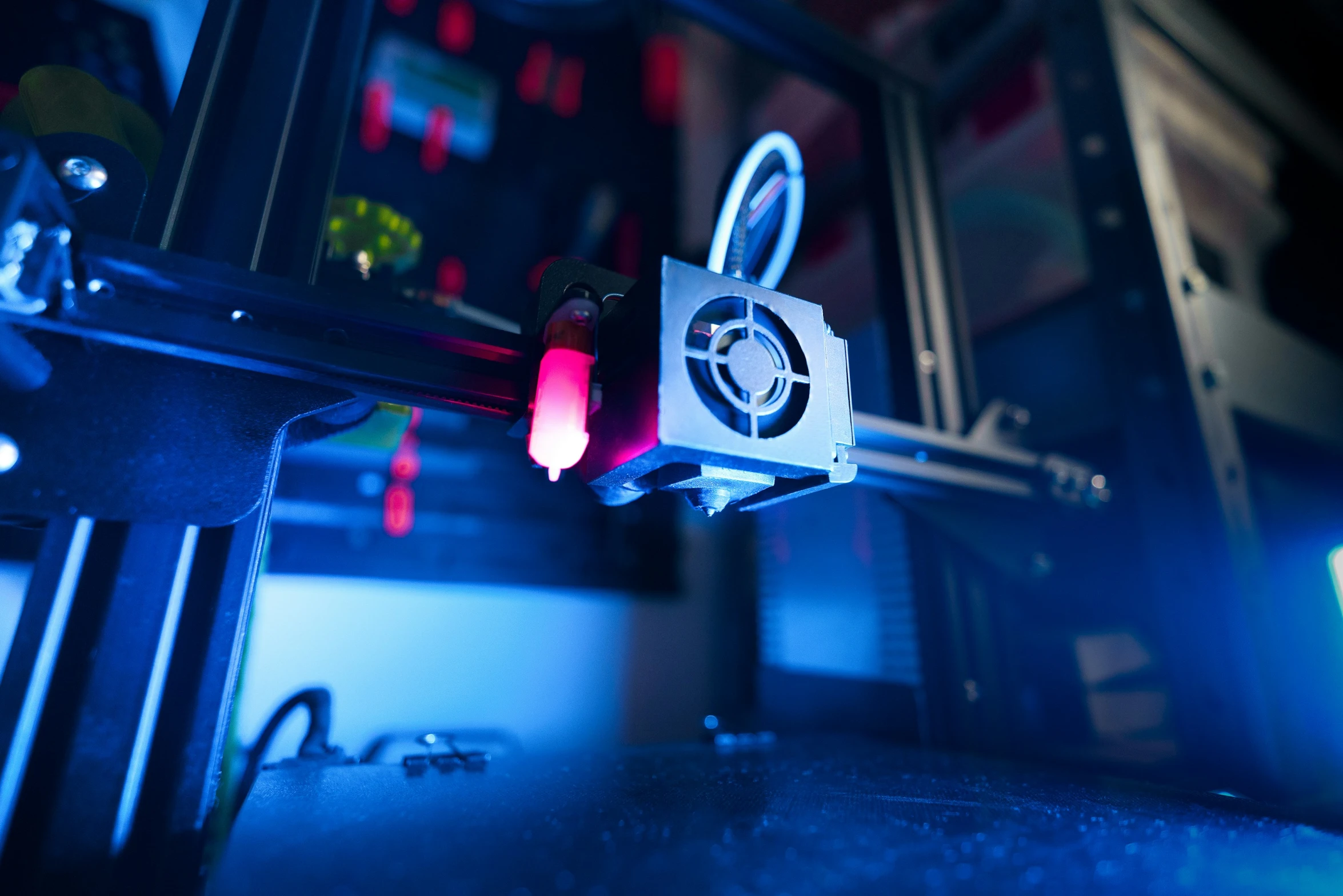 3d printer with purple light next to sink in room