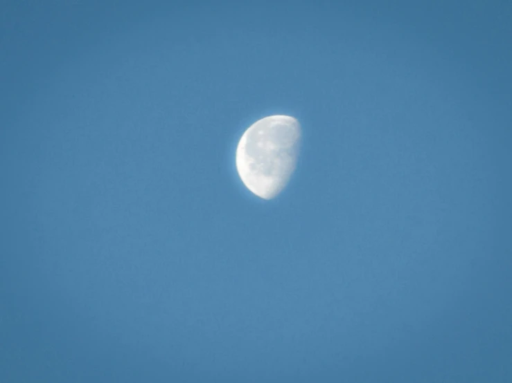 the moon is shining in the sky with a few clouds