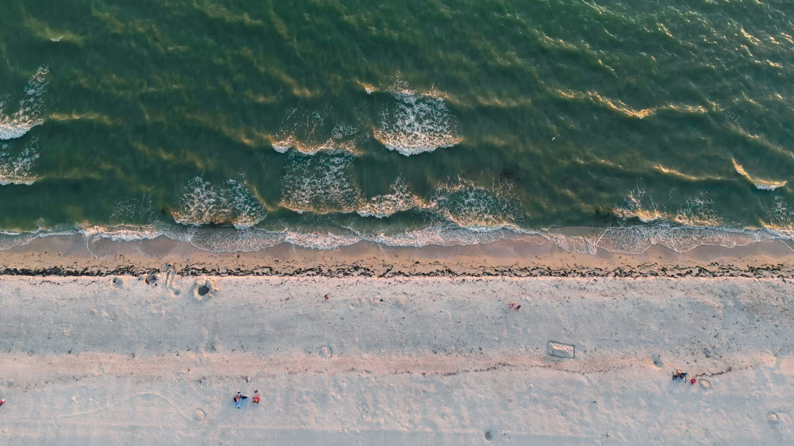 an aerial view of a beach with blue water